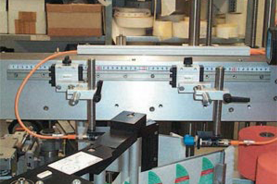 Pemandu rel drylin® T dalam sistem pemberian label untuk mesin pengemasan