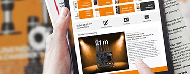 Tangan memegang tablet dan majalah