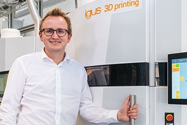 Tom Krause berdiri di depan sebuah printer SLS 3D